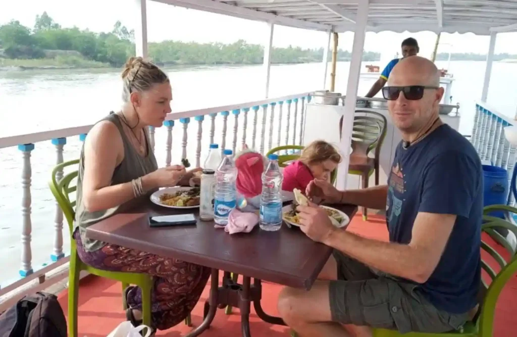 Foreign travelers enjoying lunch onboard during luxury sundarban one day tour​